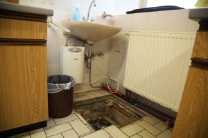 Die Leitungen des Pfarrheims müssen dringend saniert werden. Das Bild zeigt ein Loch im Boden vor einem Waschbecken.